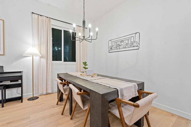 Dining room with an inviting chandelier, light wood-style floors, and baseboards | Image 6