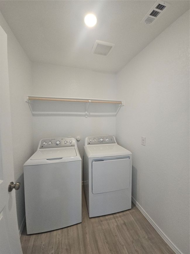 Washroom with washing machine and dryer, wood finished floors, and baseboards | Image 11