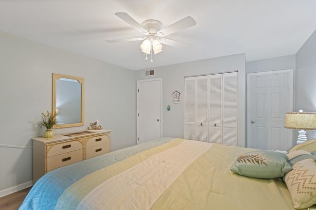Bedroom featuring a ceiling fan, baseboards, wood finished floors, visible vents, and a closet | Image 27