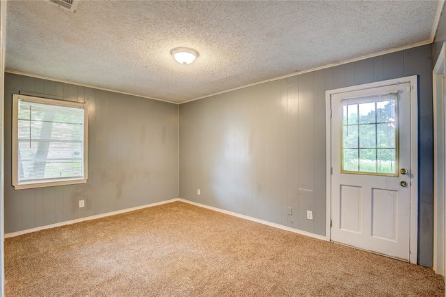 Unfurnished room featuring plenty of natural light, carpet floors, ornamental molding, a textured ceiling, and baseboards | Image 22