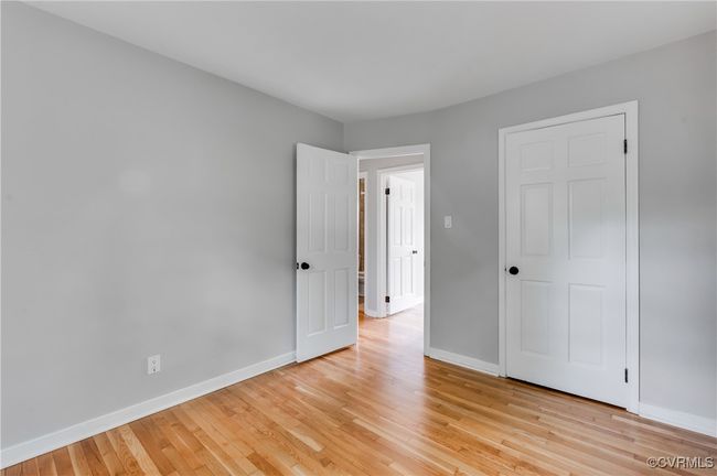 Unfurnished bedroom with light wood-type flooring and baseboards | Image 15