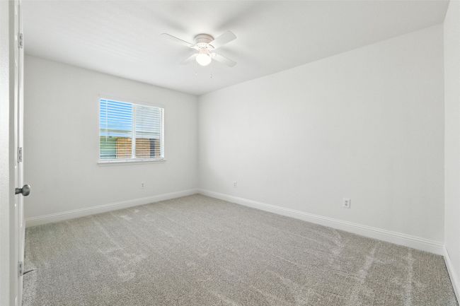 Carpeted spare room featuring a ceiling fan and baseboards | Image 16