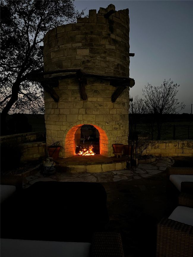 View of patio / terrace featuring a warm lit fireplace | Image 36