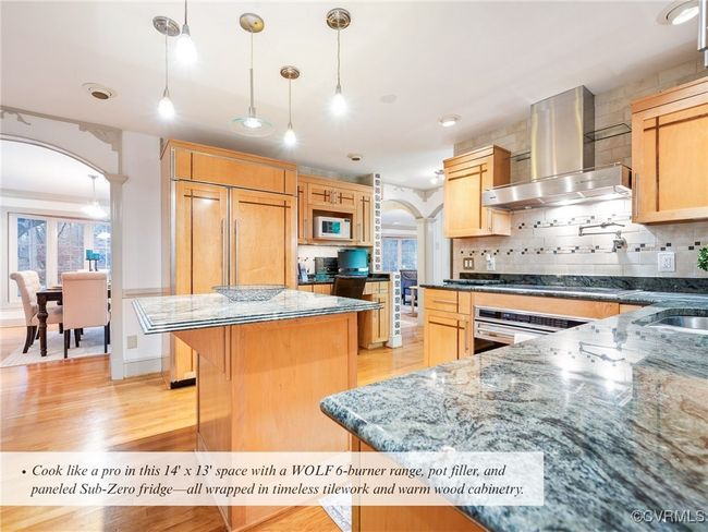kitchen features custom cabinetry, granite counters, and a passthrough window to the Florida room’s wet bar | Image 13