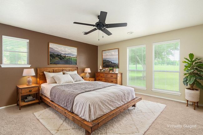 Bedroom featuring light colored carpet, baseboards, and ceiling fan | Image 29