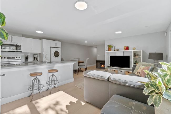 Living area featuring recessed lighting, light wood finished floors, baseboards, and stacked washing machine and dryer | Image 6