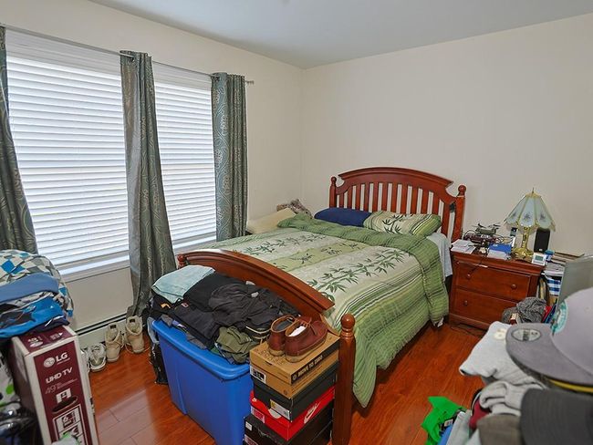 Bedroom featuring wood finished floors and a baseboard radiator | Image 29