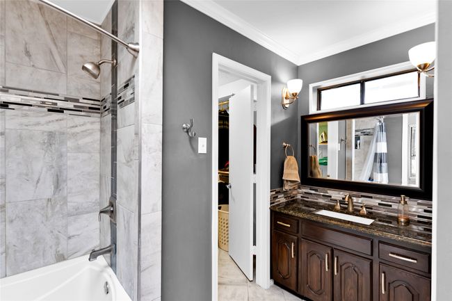 Full bath featuring vanity, shower combination, ornamental molding, and decorative backsplash | Image 26
