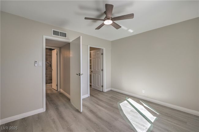 Unfurnished bedroom featuring light wood finished floors, baseboards, visible vents, and a ceiling fan | Image 28