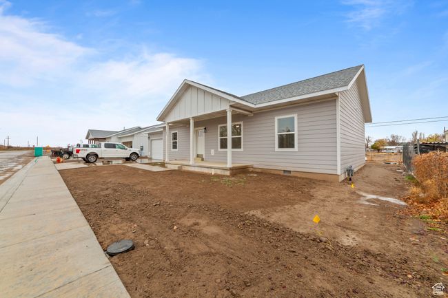 View of front facade featuring roof with shingles, an attached garage, board and batten siding, crawl space, and a porch | Image 5