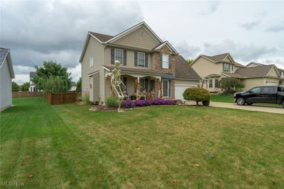 View of front facade featuring a porch, a garage, and a front yard | Image 2