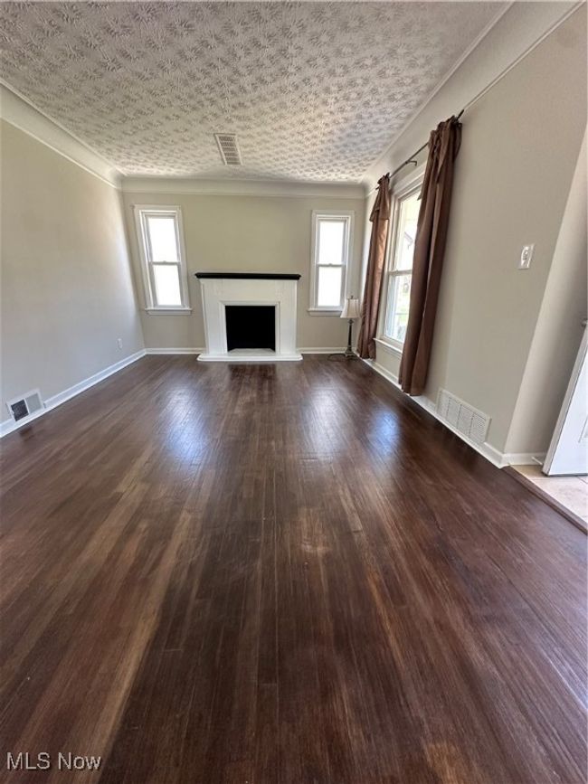 Unfurnished living room featuring visible vents and plenty of natural light | Image 19