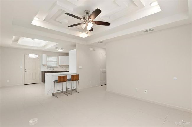 Living area with a tray ceiling and a ceiling fan | Image 8