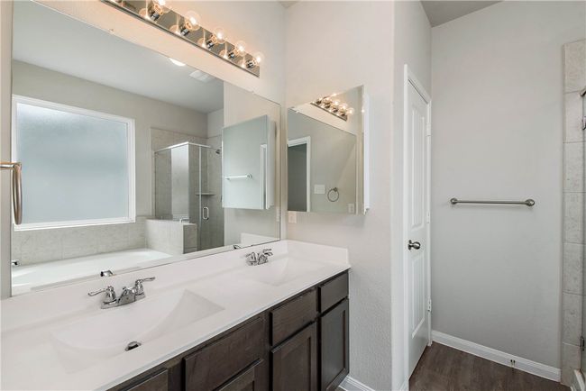 Full bath with a stall shower, wood finished floors, double vanity, and a garden tub | Image 13