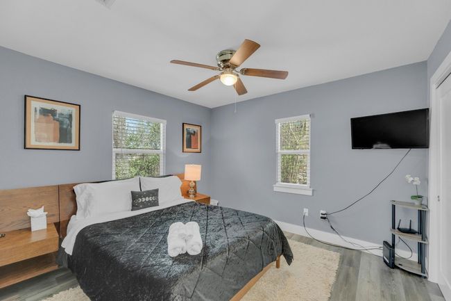 Bedroom with baseboards, ceiling fan, wood finished floors, and multiple windows | Image 18