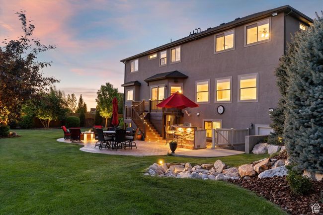 Back of house featuring stairs, stucco siding, a patio, and a yard | Image 65