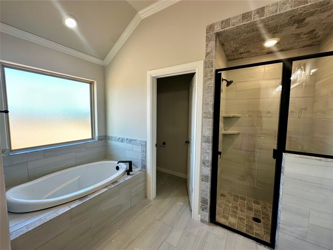 Bathroom with a garden tub, crown molding, a stall shower, and vaulted ceiling | Image 16