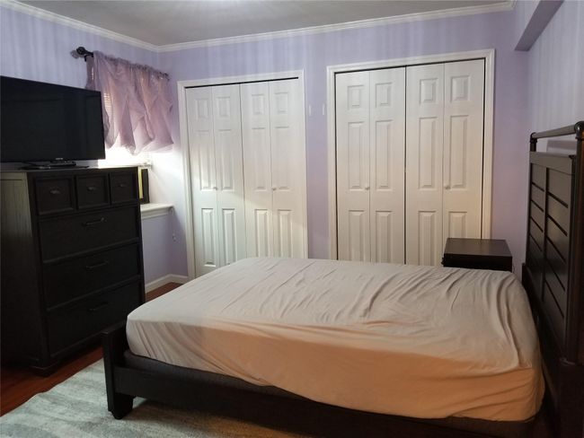 Bedroom with multiple closets, dark wood-type flooring, and crown molding | Image 11