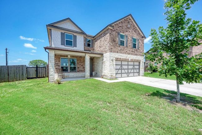 View of front of property with a garage, driveway, brick siding, and stone siding | Image 4