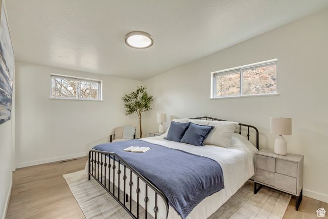 Bedroom featuring light wood-type flooring, baseboards, and visible vents | Image 11