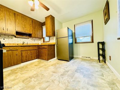 Kitchen featuring decorative backsplash, stainless steel refrigerator, and ceiling fan | Image 3