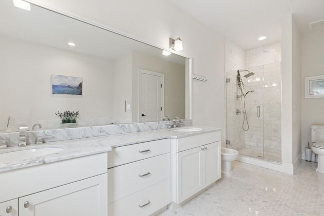 Bathroom with toilet, double vanity, a shower stall, recessed lighting, and tile patterned flooring | Image 12
