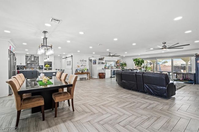Dining space with ornamental molding, ceiling fan with notable chandelier, and recessed lighting | Image 12