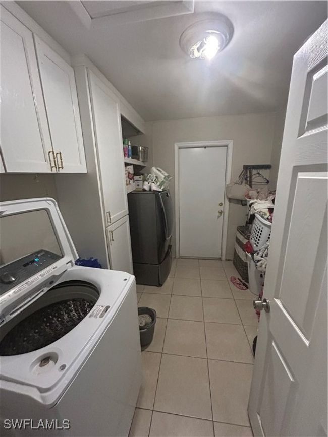 Laundry room with washer / dryer, cabinet space, and light tile patterned floors | Image 8