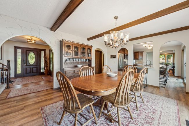 Welcoming foyer and dining area with arched walkways, built-in hutch, and rich wood finishes. | Image 11