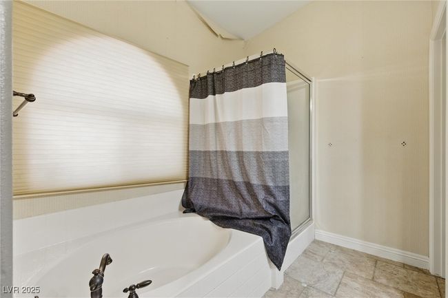 Bathroom with baseboards, a bath, and a stall shower | Image 31