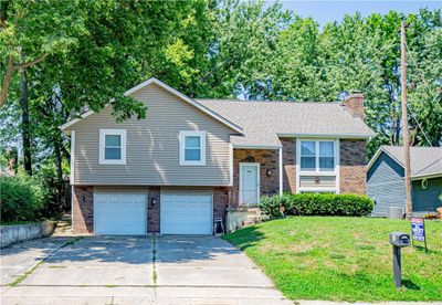 Raised ranch with a front lawn and a garage | Image 1