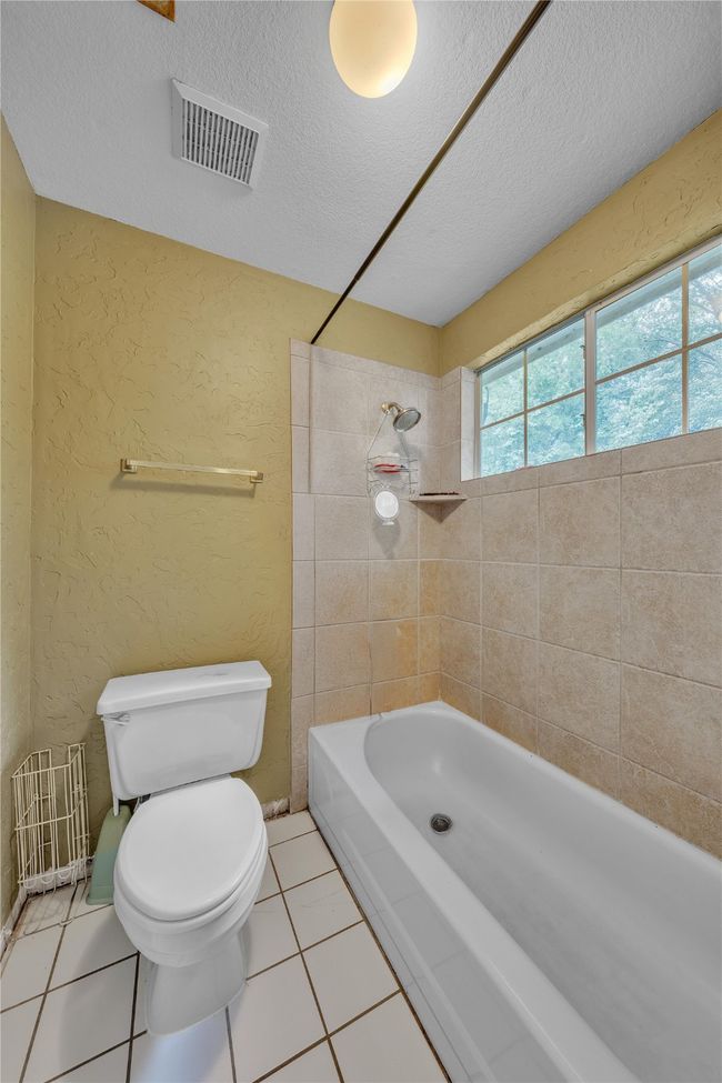 Full bath featuring a textured wall, a textured ceiling, tile patterned flooring, and bathing tub / shower combination | Image 27