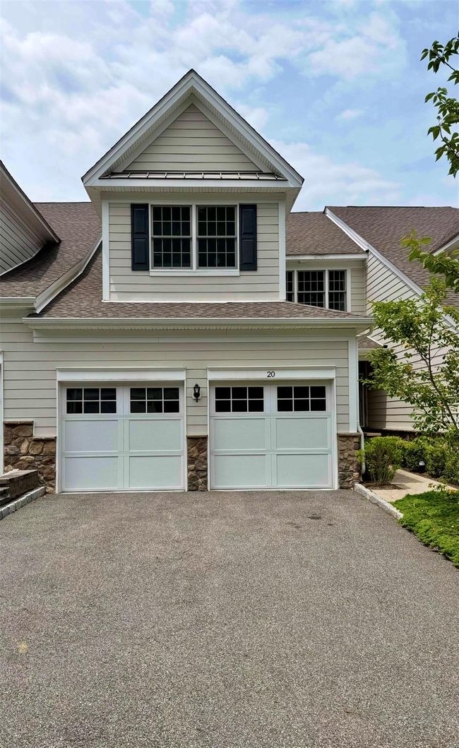 View of front of property featuring stone siding, asphalt driveway, a shingled roof, and a garage | Image 18