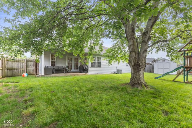 fenced backyard featuring french doors, a storage unit, a patio, and outdoor lounge area | Image 33