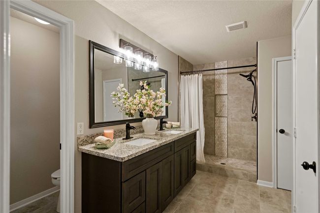 Primary bathroom with recent updates which include: granite countertop, sinks and faucets, tile in shower and bathroom floor. | Image 28