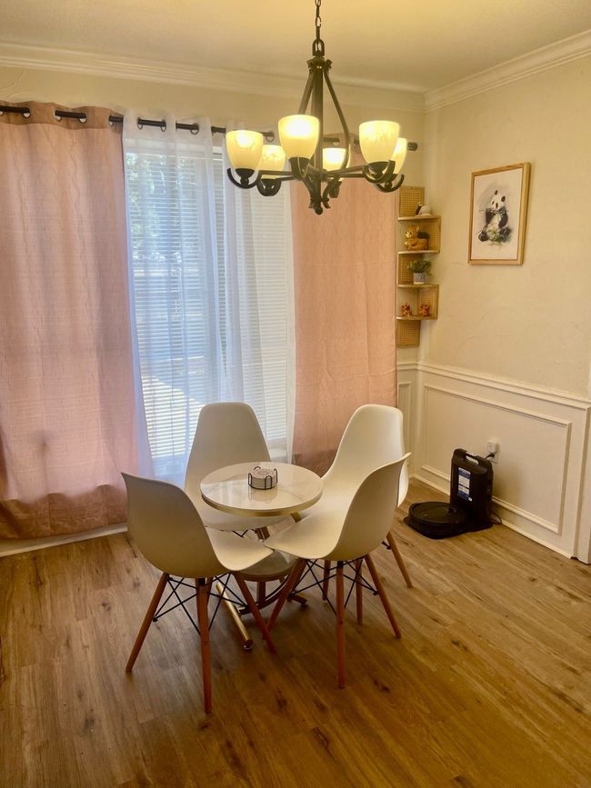 Dining area with a chandelier, wood finished floors, and crown molding | Image 9