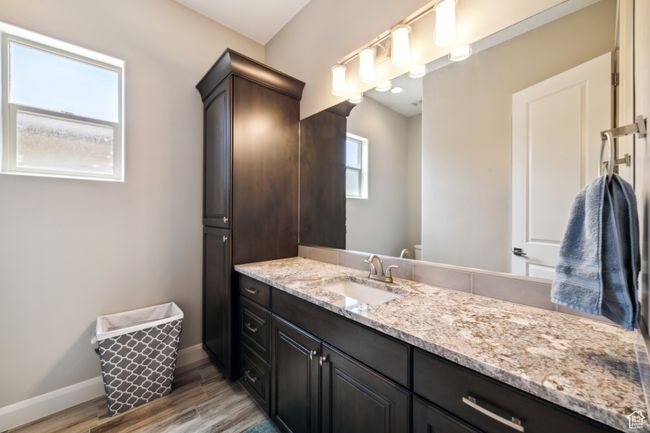 Bathroom featuring wood finished floors, vanity, and baseboards | Image 26