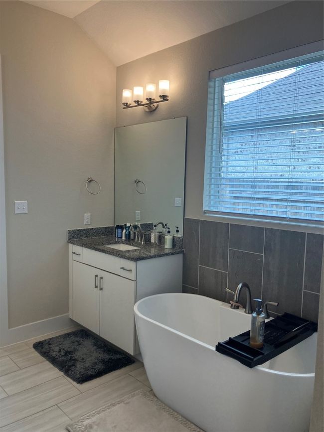 Bathroom with vanity, a freestanding tub, and vaulted ceiling | Image 12