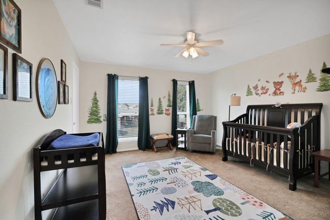 Carpeted bedroom with a crib and ceiling fan | Image 18