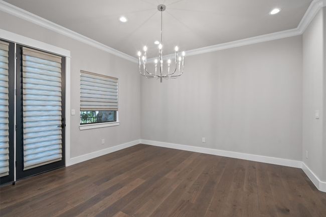 Spare room featuring crown molding, a chandelier, baseboards, dark wood-style floors, and recessed lighting | Image 7