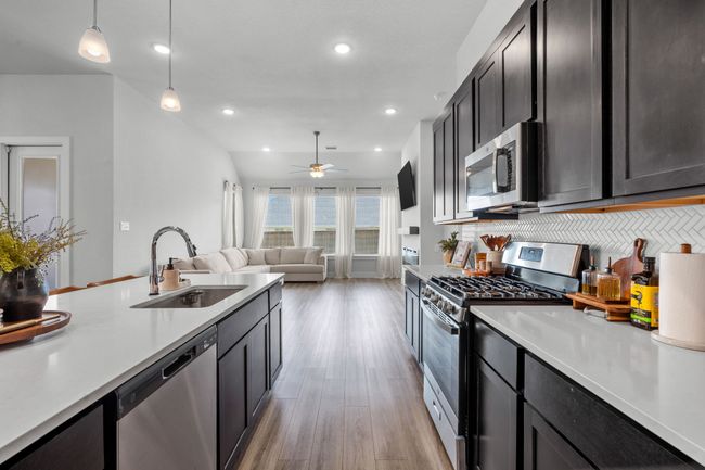 Kitchen featuring appliances with stainless steel finishes, light wood-style floors, recessed lighting, decorative light fixtures, and open floor plan | Image 15