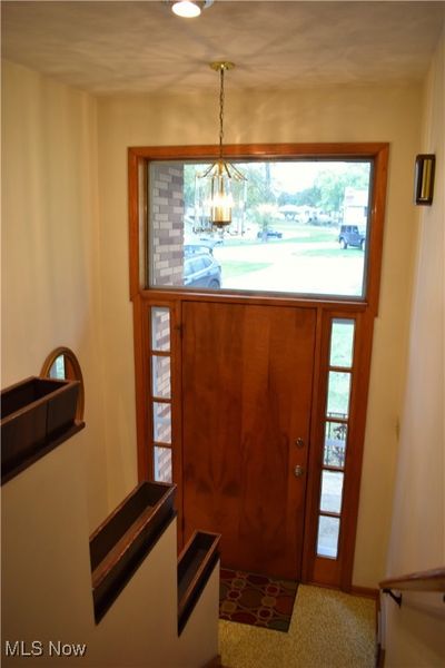 Foyer entrance featuring a notable chandelier, a wealth of natural light, and carpet floors | Image 2