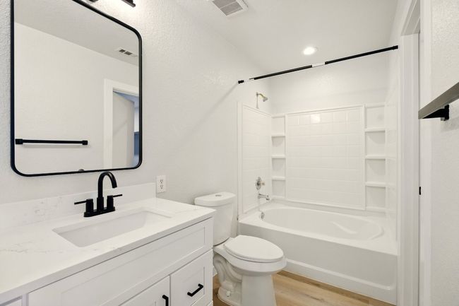 Primary bath with dual vanities, shaker cabinetry and vinyl plank flooring | Image 14