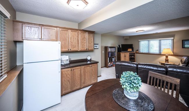 Another view of the family room with overhead lighting, counter space with cabinets above & below, & nicely placed refrigerator. | Image 27