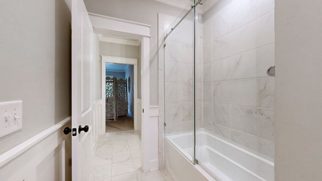 Jack & Jill shared tub/shower combo with a sleek glass door and tile surround—perfectly positioned between both bedrooms for added functionality. | Image 48