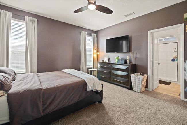 Carpeted bedroom featuring ceiling fan and connected bathroom | Image 20
