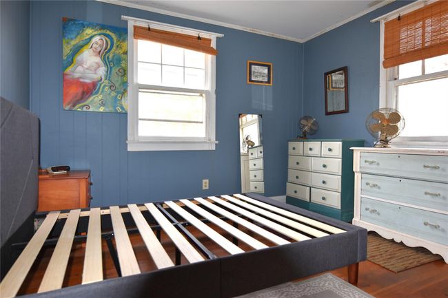 Bedroom with ornamental molding and wood finished floors | Image 9