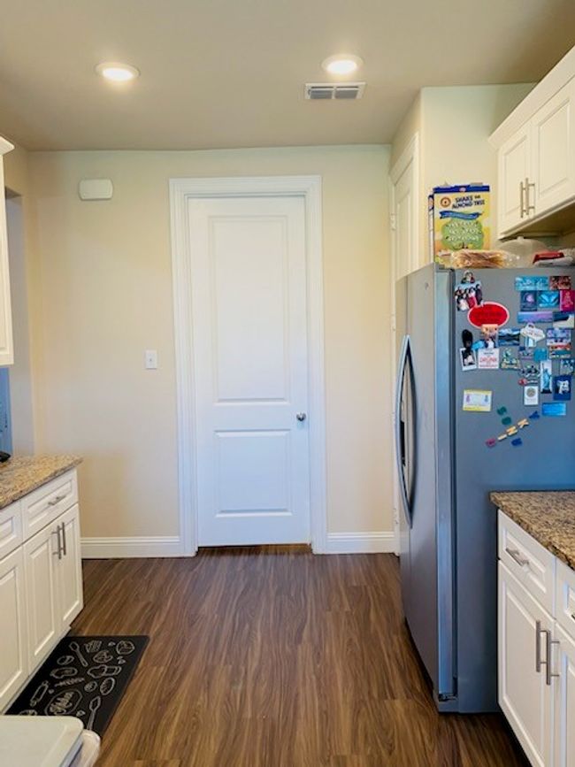 Kitchen featuring freestanding refrigerator, dark wood-type flooring, light stone counters, white cabinets, and recessed lighting | Image 17