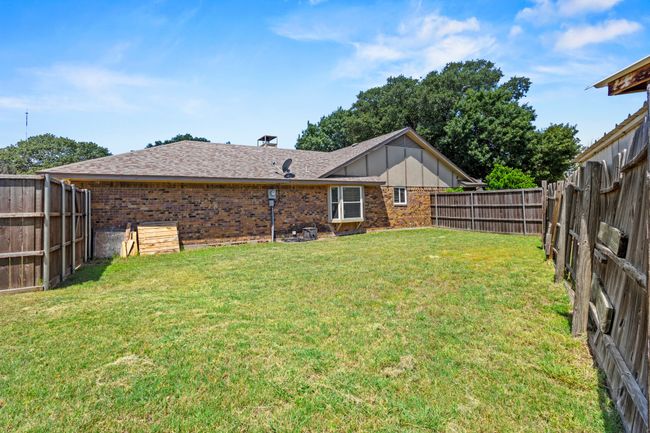 Rear view of house featuring brick siding, board and batten siding, and a fenced backyard | Image 21