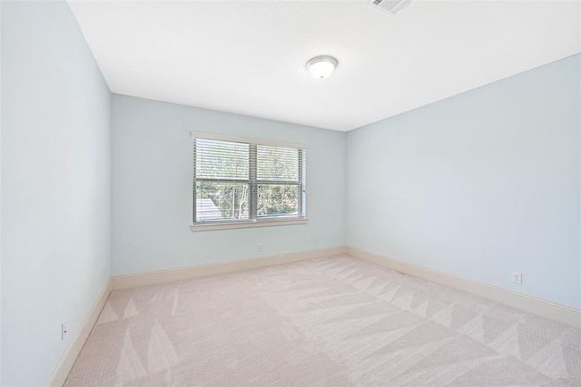 Light-filled secondary bedroom with soft carpet, fresh paint, and a large window offering serene views. A versatile space perfect for guests, a home office, or playroom. | Image 31